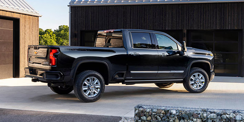 Chevrolet Silverado parked in front of a rustic barn, showcasing its sleek design against a rural backdrop.