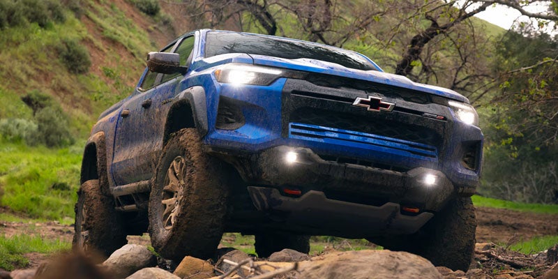 A Chevrolet Colorado navigating through rugged, rocky terrain, showcasing its off-road capabilities.